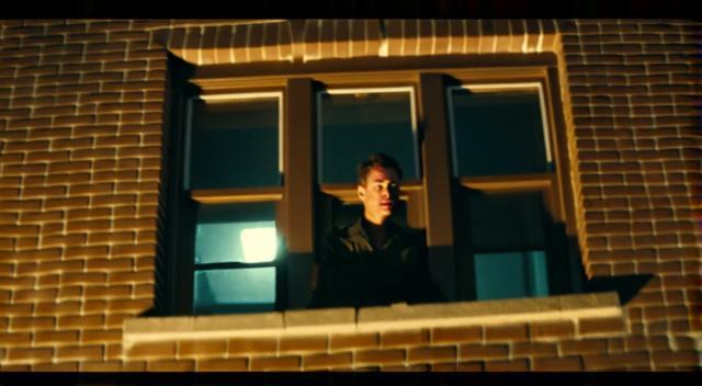 man hanging outside of second story window