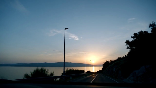 Video Reference N1: Sky, Cloud, Street light, Water, Afterglow, Dusk, Sunlight, Tree, Body of water, Road surface