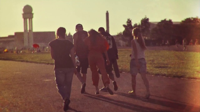 Video Reference N0: Atmospheric phenomenon, Morning, Fun, Sunlight, Evening, Team, Person, Outdoor, Grass, Walking, Man, Standing, Field, Holding, Woman, Carrying, Playing, Street, Wearing, Cross, Riding, Game, Group, Player, Young, People, Skiing, Ball, City, Elephant, Soccer, Red, Sunset, Track, Clothing, Footwear, Sky, Tree