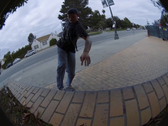 Video Reference N17: Photography, Fisheye lens, Recreation, Person, Outdoor, Man, Building, Side, Young, Walking, Sidewalk, Park, Path, Riding, Street, Standing, Holding, Hill, Boy, Board, Water, Yellow, Road, Jumping, Snow, Ramp, People, Air, Sky, Clothing, Footwear, Car, Trousers, Tree, Jeans