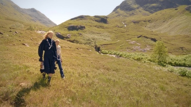 Video Reference N2: Mountainous landforms, Highland, Mountain, Fell, Hill, Grassland, Wilderness, Ridge, Adventure, Grass, Person, Outdoor, Nature, Man, Field, Standing, Green, Hillside, Cow, Covered, Country, Brown, Grassy, Wearing, Walking, Riding, Rock, Horse, Slope, Snow, White, Skiing, Hiking, Sky, Hiking equipment, Clothing