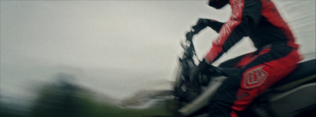 Video Reference N3: Red, Photography, Vehicle, Recreation, Personal protective equipment, Fictional character, Shoe, Sitting, Riding, Man, Wearing, Motorcycle, White, Skiing, Blur
