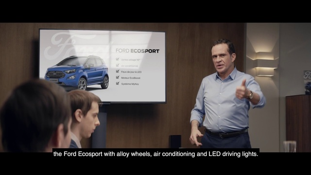 Video Reference N2: Automotive design, Vehicle, Car, Minivan, Mid-size car, Media, Brand, Advertising, Car dealership, Person, Indoor, Man, Standing, Screen, Looking, Front, Photo, Woman, Table, Television, Holding, People, Monitor, Room, Sign, Computer, Desk, Large, Mirror, Talking, Phone, Video, Playing, Display, Living, Group, White, Shirt, Player, Text, Screenshot, Land vehicle, Human face