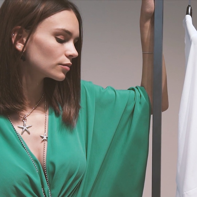 Video Reference N0: Green, Shoulder, Turquoise, Neck, Dress, Teal, Arm, Fashion, Joint, Fashion design, Person, Woman, Indoor, Clothing, Lady, Shirt, Girl, Looking, Holding, Sitting, Smiling, Young, Hair, Using, White, Wearing, Table, Laptop, Blue, Phone, Remote, Wall, Human face, Necklace, Fashion accessory