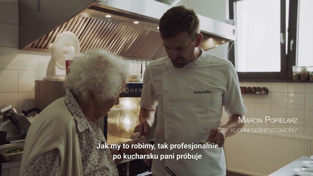Video Reference N0: Job, Chef, Cook, Person, Indoor, Kitchen, Man, Food, Preparing, Looking, Standing, Making, Front, Table, Woman, Cooking, Counter, Young, Holding, Cake, Cutting, Eating, People, Oven, Computer, Plate, Clothing, Human face, Text, Meal