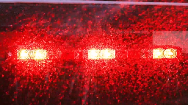 Video Reference N1: Red, Automotive lighting, Light, Lighting, Automotive tail & brake light, Auto part, Lit, Dark, Sitting, Food, Blurry, Yellow, Train, Stop, Night, Rain, Room, Soft drink, Abstract, Coquelicot