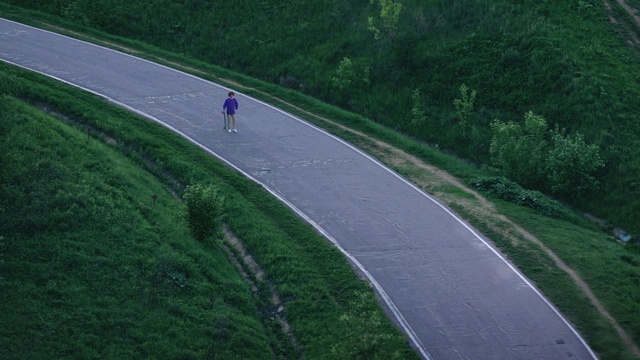 Video Reference N0: road, green, infrastructure, path, grass, tree, highway, asphalt, sky, plant, Person