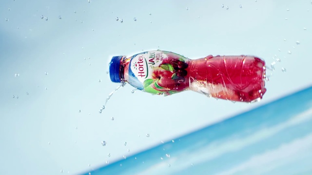 Video Reference N1: Water, Liquid, Drink, Carbonated water, Food, Skiing, Covered, Snow, Sitting, Clear, White, Red, Table, Blue, Holding, Laying, Man, Bottle, Splash, Beverage, Soft drink, Day