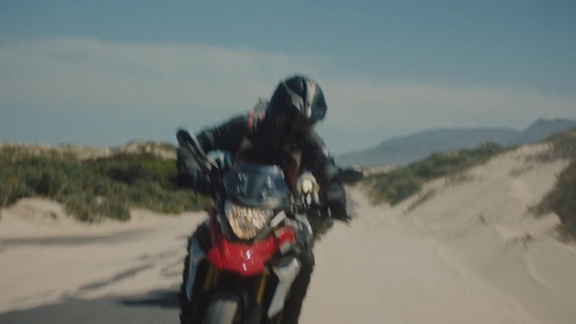 Video Reference N4: Motorcycle, Motorcycling, Vehicle, Natural environment, Sand, Landscape, Extreme sport, Racing, Helmet, Personal protective equipment