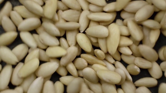 Video Reference N0: Food, Pine nut, Vegetarian food, Ingredient, Cuisine, Plant, Seed, Nuts & seeds, Produce, Superfood, Nut, Fruit, Pile, Store, Several, Sitting, Photo, Large, Topped, Sliced, Fries, Chocolate, Counter, Banana, Bunch, Stacked, Plate, Ready, Close, Table, Green, Pan, Many, Group, Display, Oven, Arranged
