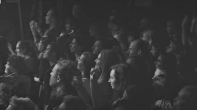 Video Reference N0: Crowd, People, Black, Photograph, White, Audience, Monochrome, Black-and-white, Monochrome photography, Snapshot, Person, Photo, Standing, Dark, Woman, Holding, Group, Man, Sitting, Crowded, Room, Large, Street, Blurry, Pizza, Human face, Black and white