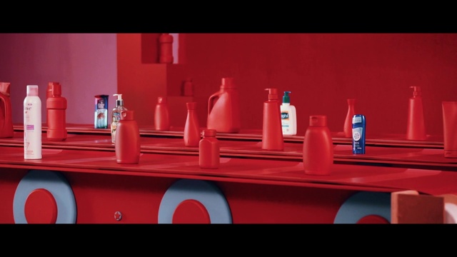 Video Reference N9: Red, Table, Person, Indoor, Sitting, Small, Photo, Orange, Counter, Holding, Woman, Different, Man, Large, Food, Pink, Room, Mirror, Display, Standing, Kitchen, White, Refrigerator, Vase, Bottle, Soft drink, Drink