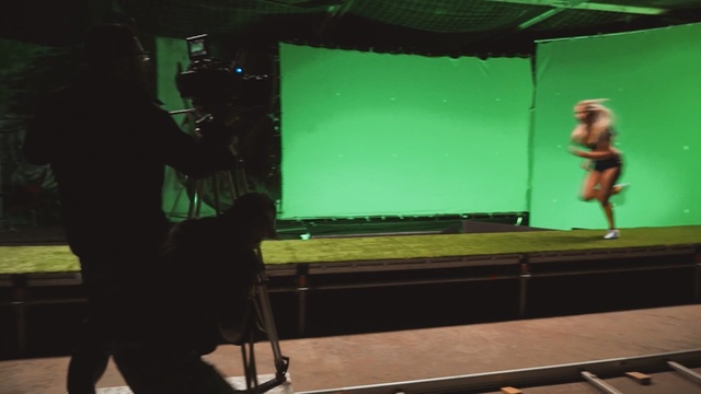 Video Reference N0: Green, Standing, Projection screen, Stage, Technology, Display device, Electronic device, Performance, Music venue, Film studio, Person