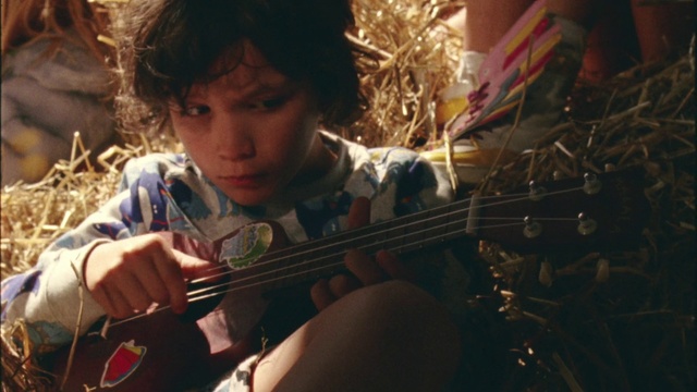 Video Reference N1: String instrument, Musical instrument, Violin, Child, Music, Musician, Guitar, Plucked string instruments, Play, Person, Indoor, Sitting, Young, Boy, Little, Looking, Holding, Man, Instrument, Wearing, Girl, Using, Small, Food, Table, Shirt, Eating, Woman, Standing, Playing, Plate, Phone, Cello, Human face, Bowed instrument, Bass
