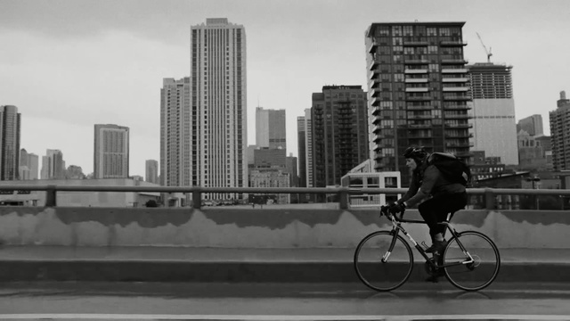 Video Reference N1: White, Bicycle, Urban area, Black, Metropolitan area, City, Daytime, Black-and-white, Human settlement, Mode of transport, Person