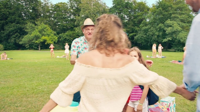 Video Reference N2: Fun, Summer, Shoulder, Picnic, Recreation, Event, Grass, Leisure, Vacation, Child, Person, Outdoor, Park, Man, Holding, Frisbee, People, Standing, Field, Young, Table, Woman, Cake, Boy, Playing, Group, Grassy, Riding, White, Red, Game, Plate, Tree, Clothing, Smile, Dress, Girl, Human face
