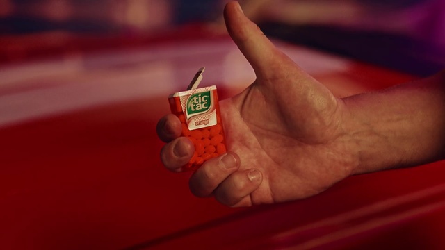 Video Reference N1: Red, Finger, Hand, Thumb, Nail, Photography, Games, Gesture, Person, Indoor, Holding, Table, Sitting, Small, Food, Orange, Man, Remote, Close, Control, Phone, Screen, White, Plate