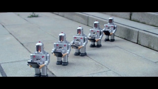 Video Reference N0: Robot, Asphalt, Marching percussion, Musician, Toy, Fictional character, Marching band, Action figure