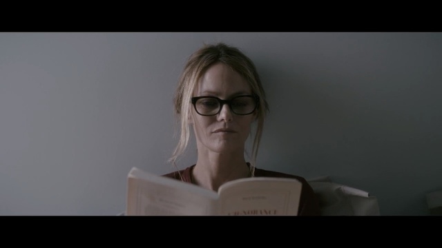 Video Reference N1: call, person, businesswoman, woman, book, reading, white wall