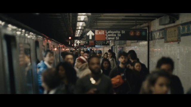 Video Reference N0: Crowd, People, Transport, Snapshot, Urban area, Metropolitan area, Darkness, Public transport, Photography, Fun, Person, Building, Train, Standing, Woman, Front, Group, Man, Photo, Subway, Station, Walking, Bus, Store, Holding, Restaurant, Phone, Sign, Street, Human face, City, Screenshot, Clothing