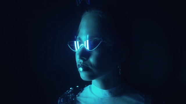 Video Reference N5: Blue, Eyewear, Light, Darkness, Organism, Human, Photography, Cool, Technology, Glasses, Person, Dark, Wearing, Looking, Woman, Holding, Man, Smiling, Standing, Black, Shirt, Young, Red, Room, White, Human face, Face, Portrait