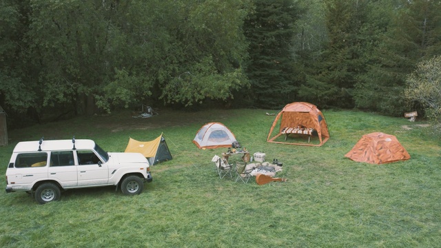 Video Reference N2: car, camping, vehicle, motor vehicle, grass, plant, lawn, tree, landscape, tent