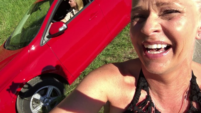 Video Reference N16: Vehicle, Red, Vehicle door, Car, Pink, Smile, Photography, Leg, Summer, Grass, Person, Outdoor, Man, Smiling, Wearing, Posing, Glasses, Black, Holding, Woman, Front, Standing, Hot, Green, Talking, Phone, Close, Field, Young, Large, Street, White, Hat, Hotdog, Human face, Land vehicle, Clothing
