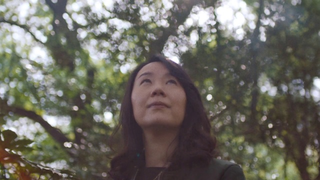 Video Reference N3: Hair, Face, Nature, Tree, Beauty, Natural environment, Head, Branch, Smile, Sunlight