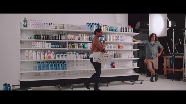 Video Reference N2: Product, Beauty, Snapshot, Retail, Service, Building, Pharmacy, Advertising, Shelf, Furniture, Indoor, Person, Man, Standing, Front, Woman, Table, Holding, Young, People, Room, Board, Refrigerator, Doing, Dog, Video, White, Kitchen, Playing, Group, Text, Bookcase