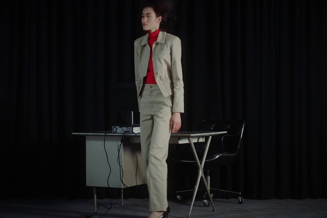Video Reference N3: Performance, Suit, Gentleman, Standing, Talent show, Performing arts, Event, Formal wear, Scene, Public speaking, Person, Curtain, Necktie, Man, Front, Holding, Wearing, Dressed, Black, Dress, Suitcase, Dark, White, Table, Woman, Red, Room, Young, Phone, Luggage, Clothing, Floor, Furniture, Piano, Microphone