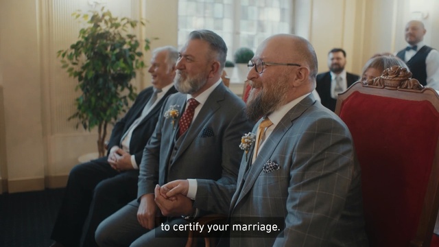 Video Reference N1: Event, Community, Businessperson, Room, Management, House, Official, Tourism, Person, Man, Indoor, Suit, Holding, Standing, Table, Looking, Front, People, Talking, Glasses, Wine, Woman, Glass, Phone, Group, Living, Red, White, Clothing, Human face, Ceremony, Tie, Wedding, Groom