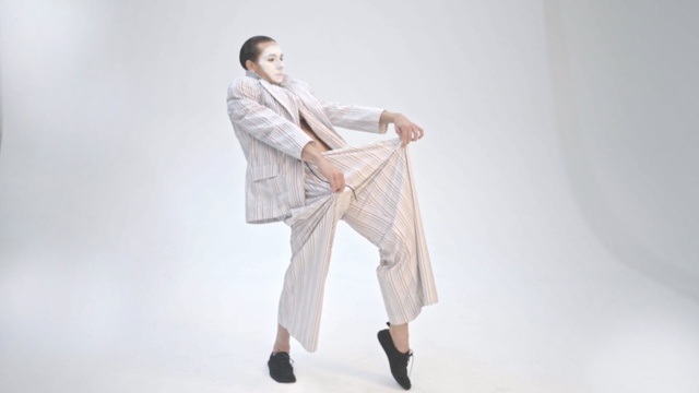Video Reference N6: White, Clothing, Outerwear, Suit, Footwear, Neck, Trousers, Formal wear, Robe, Beige