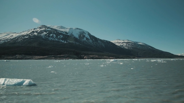 Video Reference N3: Body of water, Mountain, Mountainous landforms, Sky, Highland, Mountain range, Ice, Glacial lake, Sound, Sea