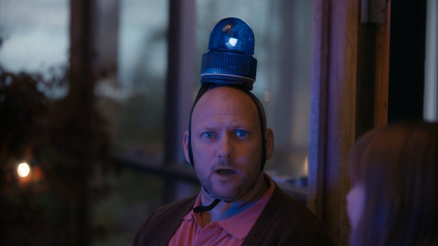 Video Reference N3: Blue, Head, Human, Forehead, Night, Screenshot, Electric blue, Person, Necktie, Wearing, Man, Building, Looking, Standing, Front, Suit, Young, Shirt, Camera, Hat, Purple, Holding, Smiling, Uniform, Table, Neck, White, Food, Red, Street, Human face, Clothing
