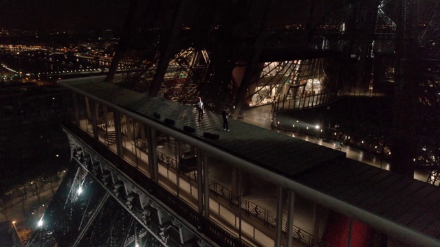 Video Reference N5: Metropolitan area, Night, Urban area, City, Architecture, Metropolis, Cityscape, Darkness, Midnight, Screenshot, Building, Outdoor, Bridge, Train, Street, Bus, Track, View, Long, Large, Platform, Light, Clock, Many, Tower, Traffic, Red, Lit, Traveling, Standing, Station, Sign, Driving, Stop, Tall, People, Decker, White, Double, Riding, Snow, Parked, Skyscraper