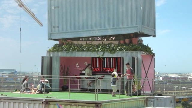 Video Reference N6: structure, shipping container, current transformer, transformer, facade, roof, building, advertising, Person