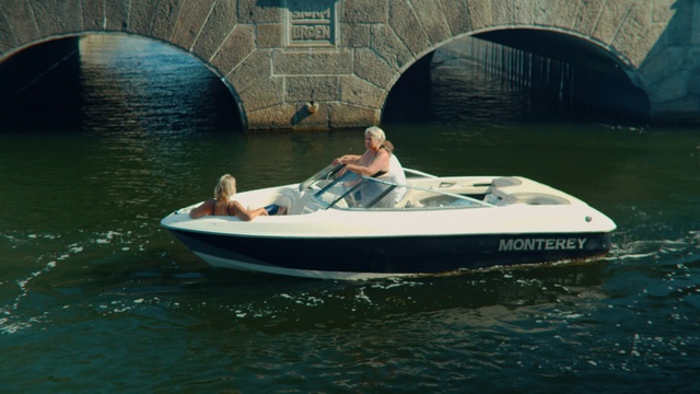 Video Reference N5: Vehicle, Water transportation, Boating, Speedboat, Boat, Recreation, Outdoor recreation, Personal water craft, Watercraft, Water sport, Water, Outdoor, Building, Small, Man, Riding, River, Woman, Sitting, Open, Little, Bridge, Young, Holding, Body, Floating, Large, Table, Dog, White, City, Motorcycle, People, Lake, Canoe, Person, Paddle, Vacation