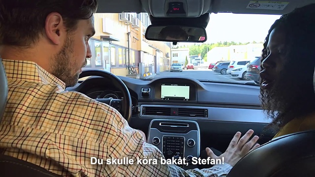Video Reference N17: Car, Vehicle, Luxury vehicle, Driving, Electronics, Automotive design, Steering wheel, Technology, Center console, Person, Man, Looking, Sitting, Front, Truck, Holding, Bus, Table, Standing, Seat, Glasses, Phone, Black, Dog, Woman, Young, Wearing, People, Street, Boat, Train, Land vehicle, Auto part, Car seat, Mirror, Automotive, Automotive mirror, Head restraint, Rear-view mirror, Vehicle door, Control panel