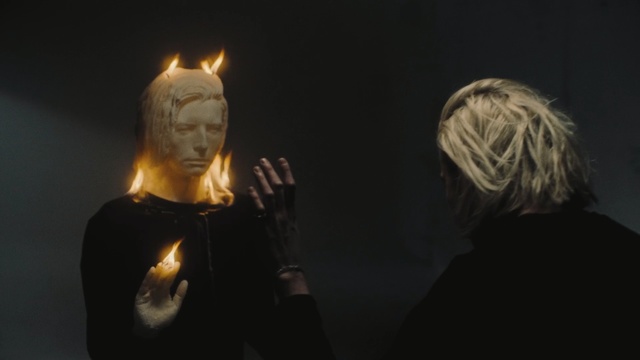 Video Reference N3: Lighting, Darkness, Sky, Photography, Fire, Performance, Night, Flame, Art, Person, Dark, Man, Looking, Front, Woman, Standing, Lit, Holding, Black, Glasses, Wearing, Table, Light, Young, Phone, Video, People, Playing, Statue, Human face, Candle