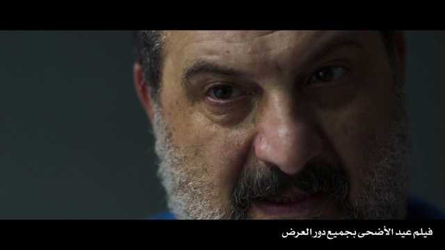 Video Reference N3: Face, Facial hair, Nose, Beard, Facial expression, Moustache, Chin, Head, Forehead, Skin, Person, Man, Looking, Indoor, Wearing, Dark, Holding, Smiling, Suit, Close, Black, White, Large, Blue, Red, Food, Shirt, Eyes, Human face, Human beard, Screenshot, Eyebrow, Portrait, Wrinkle, Jaw