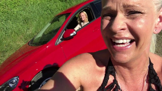 Video Reference N13: Vehicle, Car, Vehicle door, Photography, Selfie, Smile, Sport utility vehicle, City car, Person, Grass, Outdoor, Smiling, Woman, Wearing, Posing, Camera, Sitting, Red, Man, Glasses, Front, Holding, Young, Close, Black, Driving, Talking, Hot, Dog, Motorcycle, Riding, Baseball, White, Hat, Standing, Phone, Parked, Human face, Land vehicle, Clothing, Wheel