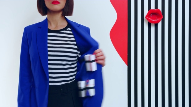 Video Reference N1: Cobalt blue, Blue, Clothing, Blazer, Outerwear, Red, Street fashion, Electric blue, Fashion, Button, Person, Holding, Shirt, Wearing, Striped, Front, Standing, Man, Posing, Woman, Black, Table, Young, Phone, Hat, White, Board, Human face, Smile