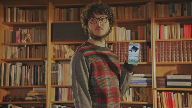 Video Reference N3: library, librarian, bookselling, bookcase, public library, shelving, book, glasses, facial hair, furniture, Person
