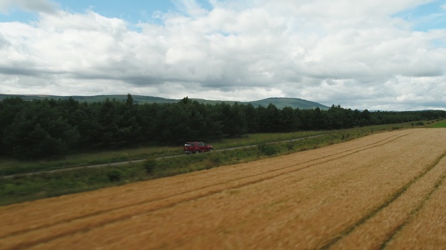 Video Reference N4: road, field, grassland, sky, plain, hill, ecosystem, highland, cloud, farm