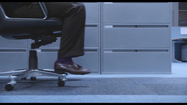 Video Reference N4: furniture, standing, floor, product, chair, flooring, desk, shoe, angle, Person