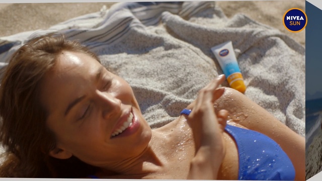 Video Reference N3: Water, Product, Skin, Sand, Hand, Sun tanning, Leisure, Vacation, Person, Indoor, Sitting, Woman, Young, Cellphone, Holding, Bed, Girl, Laying, Table, Phone, Little, Hair, Man, Blue, White, Room, Beach, Baby, Toddler