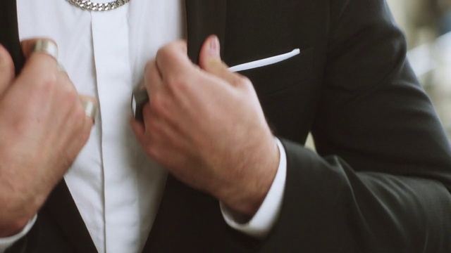 Video Reference N0: Hand, Finger, Suit, Ring, Formal wear, Gesture, Tuxedo, Wedding ring, Fashion accessory, Thumb, Person