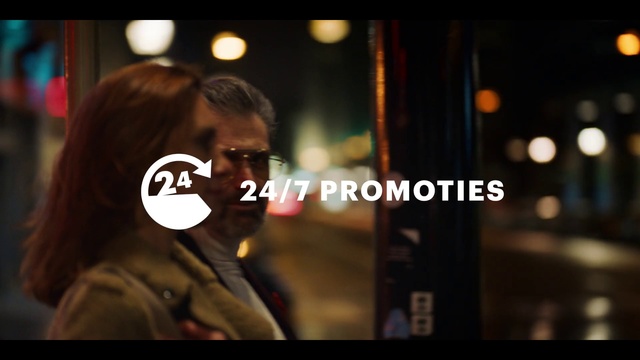 Video Reference N1: Snapshot, Night, Font, Photography, Person, Man, Black, Photo, Sitting, Front, Phone, Holding, Cellphone, Wearing, Standing, Woman, Close, Red, Street, Suit, Food, City, Bus, Sign, White, Human face, Screenshot, Glasses, Text, Clothing, Blur
