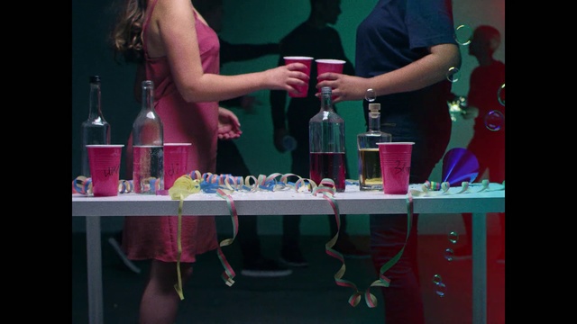 Video Reference N2: Pink, Magenta, Party supply, Fun, Drink, Table, Liqueur, Party, Nail, Person, Indoor, Sitting, Woman, Bottle, Front, Girl, Holding, Man, Wine, Young, Birthday, Food, Standing, Little, Glasses, Cake, Room, People, Soft drink, Clothing
