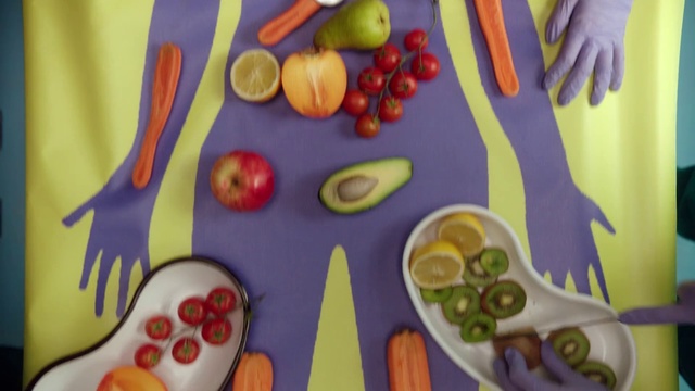 Video Reference N0: Food group, Cutlery, Vegetarian food, Organism, Art, Visual arts, Illustration, Play, Fork, Still life, Indoor, Table, Food, Cake, Small, Plate, Birthday, Sitting, Little, Decorated, Fruit, Holding, Colorful, Different, Wooden, Cutting, Board, White, Train, Vegetable, Child art, Fast food, Snack, Candy, Apple, Platter, Orange, Several